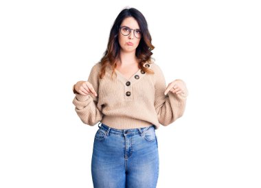 Güzel, genç, esmer bir kadın, günlük kıyafetler ve gözlük takıyor üzgün ve üzgün görünüyor, yönünü parmaklarıyla gösteriyor, mutsuz ve depresif.. 