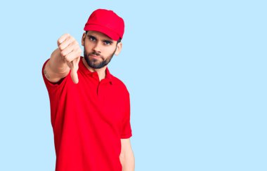 Sakallı, teslimat üniforması giyen, mutsuz, kızgın, reddedilmiş ve olumsuz jestli genç yakışıklı bir adam. kötü ifade. 