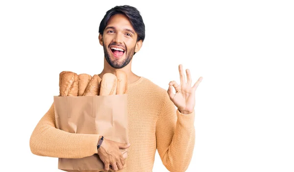 Hezký Hispánec Drží Papírový Sáček Chlebem Dělá Znamení Prsty Usmívá — Stock fotografie