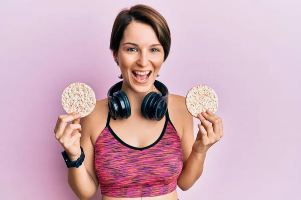 Junge Brünette Frau Mit Kurzen Haaren Trägt Sportbekleidung Reiskuchen Lächelnd — Stockfoto