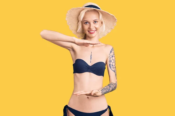 Νεαρή Ξανθιά Γυναίκα Τατουάζ Φορώντας Μπικίνι Και Καλοκαιρινό Καπέλο Gesturing — Φωτογραφία Αρχείου