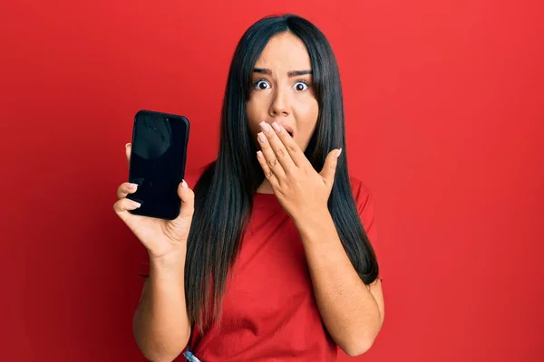 Junge Schöne Hispanische Mädchen Mit Smartphone Zeigt Bildschirm Bedeckt Mund — Stockfoto