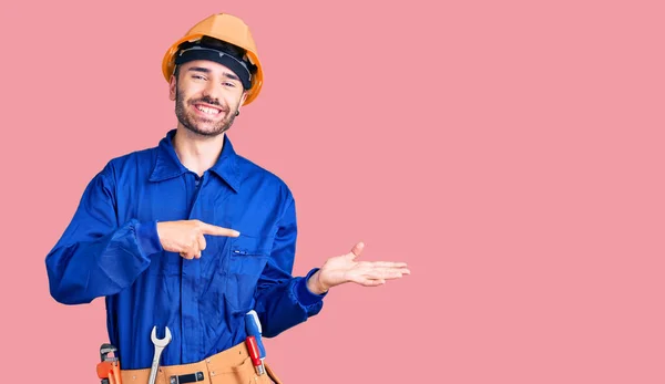 Jovem Hispânico Vestindo Uniforme Trabalhador Surpreso Sorrindo Para Câmera Enquanto — Fotografia de Stock