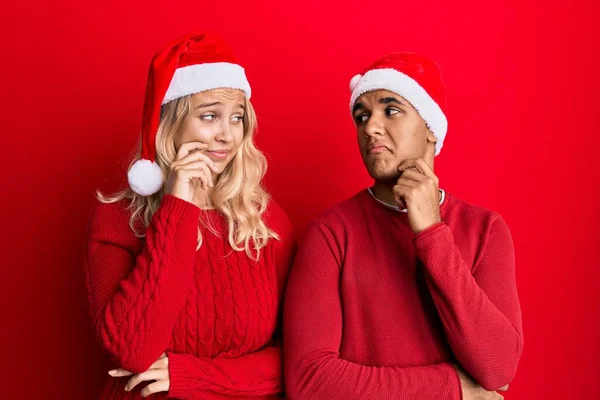 Jovem Casal Interracial Vestindo Chapéu Natal Rosto Sério Pensando Questão — Fotografia de Stock