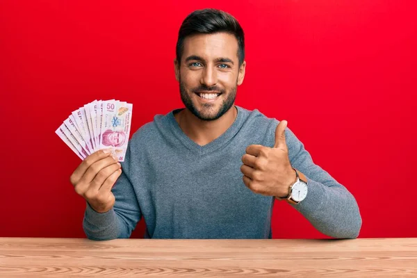 Hombre Hispano Guapo Sosteniendo Pesos Mexicanos Sonriendo Feliz Positivo Pulgar — Foto de Stock