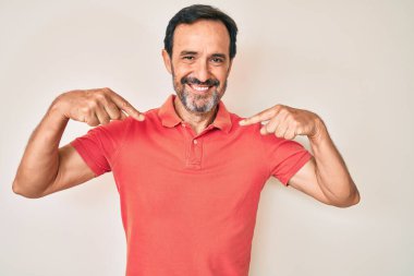 Orta yaşlı, sıradan kıyafetler giyen, kendine güvenen, gülümseyen, kendini gururlu ve mutlu gösteren bir İspanyol.. 