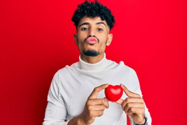 Genç Arap kalbi olan yakışıklı bir adam kameraya bakıp öpücükler savuruyor. Sevimli ve seksi. aşk ifadesi. 