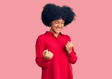 Gündelik giysiler giymiş genç Afro-Amerikalı kız kolları havada ve gözleri kapalı bir şekilde başarıyı kutluyor ve şaşırıyor. Kazanan konsept. 