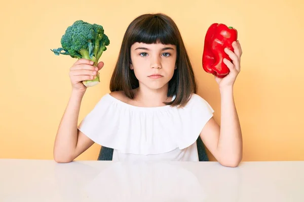 Ragazzina Con Bang Holding Broccoli Peperoncino Scettico Nervoso Accigliato Sconvolto — Foto Stock