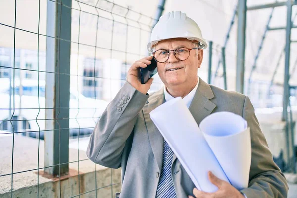 Senior Uomo Architetto Dai Capelli Grigi Possesso Cianografie Utilizzando Smartphone — Foto Stock