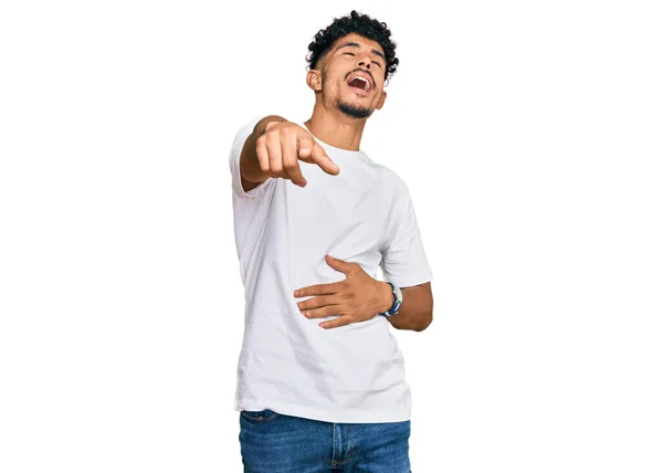 若いアラブ人の男を着てカジュアルな白いTシャツあなたを笑って 手で体 恥の表情でカメラに指を指して — ストック写真
