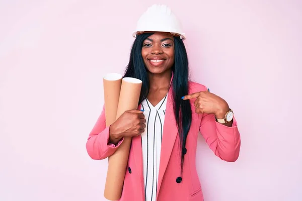 Jovem Afro Americana Vestindo Arquiteto Hardhat Segurando Plantas Apontando Dedo — Fotografia de Stock