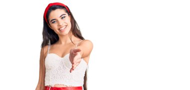 Zarif görünümlü esmer genç kız gülümseyerek dostça el sıkışmayı selamlama ve hoş geldin olarak sunuyor. başarılı iş. 