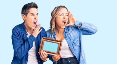 Elinde boş bir çerçeve olan iki kadın el ele verip bağırarak ve yüksek sesle çığlık atıyorlar. iletişim konsepti. 