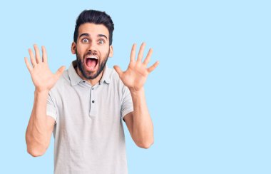 Genç, sakallı, sıradan polo giyen yakışıklı bir adam çılgınca kutlama yapıyor ve başarıya hayret ediyor. Kolları açık, gözleri açık, heyecanlı bir şekilde bağırıyor. Kazanan konsept 