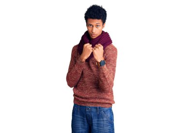 Genç Afro-Amerikan adam, günlük kışlık süveter ve eşarp giyiyor. Yumruk savunma hareketleriyle dövüşmeye hazır. Kızgın ve üzgün. 