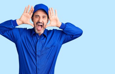 Orta yaşlı, yakışıklı, tamirci üniforması giyen, neşeli gülümseyen, elleri havada, dikizcilik oynayan bir adam. Şaşırdım ve çıktım. 