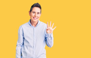 Kısa saçlı, iş kıyafetleri giyen, dört numarayı gösteren ve gülümseyen, kendinden emin ve mutlu bir genç kadın.. 