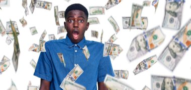 Genç Afro-Amerikan adam günlük giysiler giyiyor. Şaşırmış ve şaşırmış bir ifadeyle, korku ve heyecanlı bir yüzle..