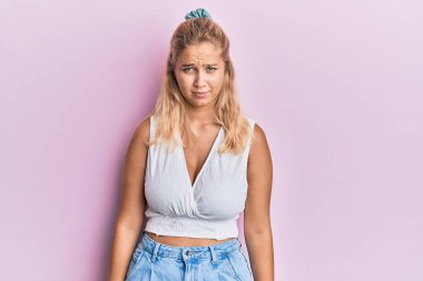 Sıradan kıyafetler giyen, kuşkucu ve gergin genç sarışın kız sorun yüzünden üzgün. negatif kişi. 