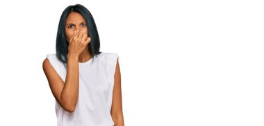 Genç Afro-Amerikalı kadın günlük kıyafetler giyiyor pis ve iğrenç bir koku alıyor, dayanılmaz bir koku, nefesini tutuyor parmakları burnunda. Kötü kokuyor. 