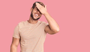 Gündelik kıyafetler giyen, gözlüklü, gülümseyen ve gülen genç, beyaz bir adam şaşırtmak için gözlerini kapatıyor. kör kavram. 