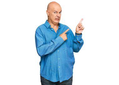 Orta yaşlı, kel bir adam, sıradan kıyafetler giyiyor. Endişeli ve gergin, endişeli ve şaşırmış bir ifade takınıyor. 