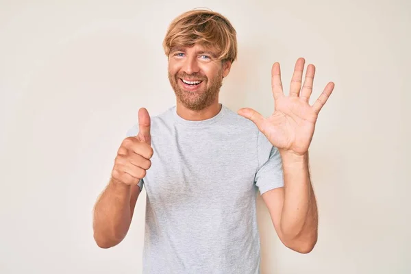 Młody Blondyn Luźnych Ubraniach Pokazuje Wskazuje Palcami Numer Sześć Uśmiechając — Zdjęcie stockowe
