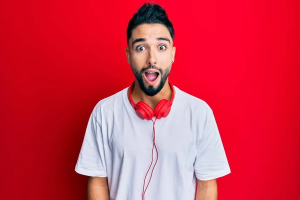 Young Man Beard Listening Music Using Headphones Afraid Shocked Surprise — Stock Photo, Image