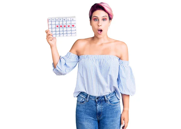 Young Beautiful Woman Pink Hair Holding Heart Calendar Scared Amazed — Stock Photo, Image