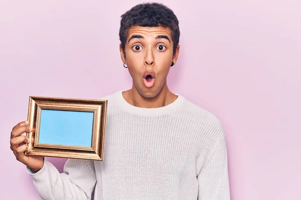 Young African Amercian Man Holding Empty Frame Scared Amazed Open — Stock Photo, Image