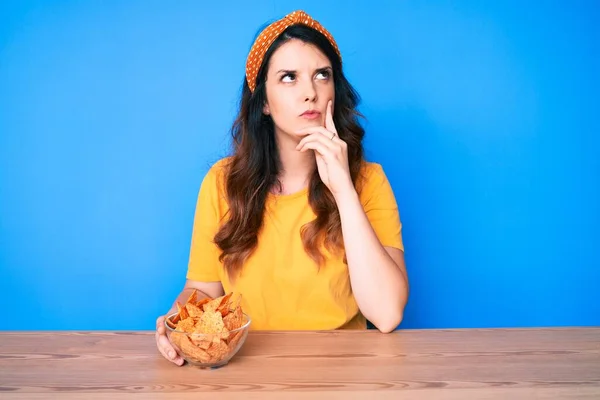 식탁에 감자칩을 아름다운 머리의 여성이 질문에 심각하게 생각하고 스러운 생각을 — 스톡 사진