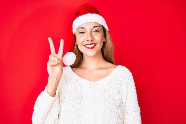 Молодая Брюнетка Рождественской Шляпе Улыбается Счастливым Лицом Подмигивая Камеру Делая — стоковое фото