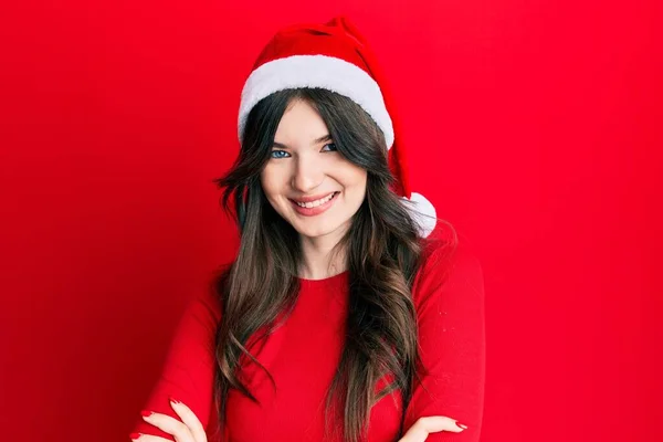年轻美丽的高加索女孩头戴圣诞礼帽 笑容满面 交叉着双臂看着相机 积极的人 — 图库照片