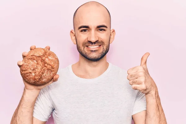 Young Handsome Bald Man Holding Bread Smiling Happy Positive Thumb — Stock Photo, Image