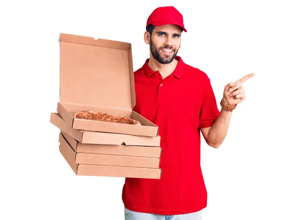 Młody Przystojny Mężczyzna Brodą Mundurze Dostawczym Trzymający Pudełka Pizzą Uśmiechnięty — Zdjęcie stockowe