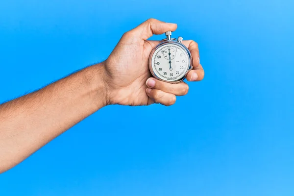 Main Jeune Homme Hispanique Utilisant Chronomètre Sur Fond Bleu Isolé — Photo