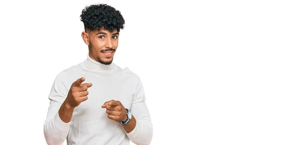 年轻的阿拉伯男子穿着休闲地冬季毛衣 手指指向相机 脸上洋溢着欢乐和滑稽的表情 充沛的精力和活力 — 图库照片