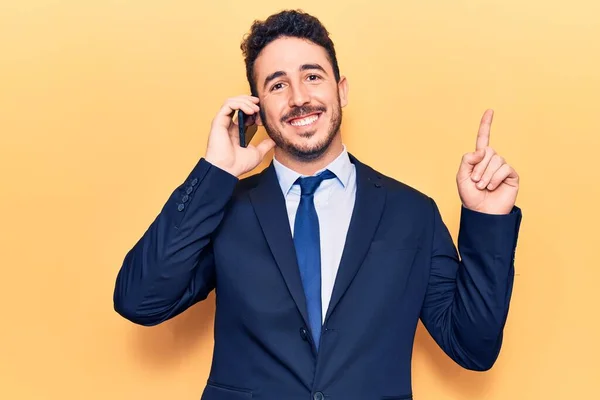 Joven Hispano Vestido Traje Conversando Smartphone Sonriendo Feliz Señalando Con — Foto de Stock