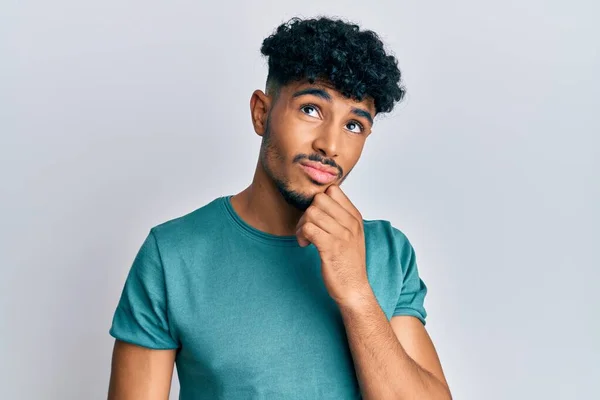 Jovem Árabe Bonito Homem Vestindo Roupas Casuais Rosto Sério Pensando — Fotografia de Stock