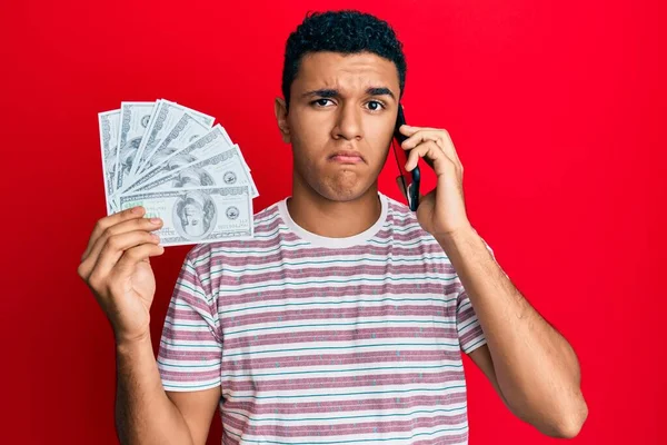 Hombre Árabe Joven Teniendo Conversación Hablando Teléfono Inteligente Sosteniendo Dólares —  Fotos de Stock