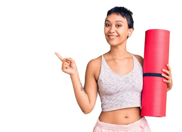 Mujer Joven Sosteniendo Esterilla Yoga Sonriendo Feliz Señalando Con Mano — Foto de Stock