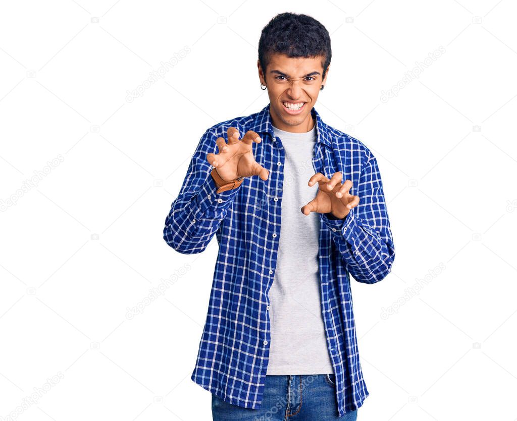Young african amercian man wearing casual clothes smiling funny doing claw gesture as cat, aggressive and sexy expression 