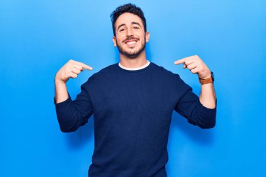 Günlük kıyafetler giyen, kendine güveni olan, kendini gururlu ve mutlu gösteren genç İspanyol bir adam.. 