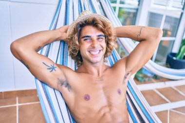 Genç İspanyol adam rahatlamış gülümsüyor mutlu bir şekilde terasta yatıyordu..