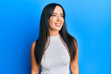 Gündelik kıyafetler giyen genç ve güzel bir İspanyol kız. Tarafsız görünmeye çalışıyor. Profil pozu, doğal bir yüz ve kendine güvenen bir gülümseme.. 