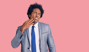 Yakışıklı Afro saçlı, iş ceketi giyen, diş ağrısı ya da diş hastalığından dolayı ağzı ağrıyan ağıza dokunan afro-amerikalı bir adam. dişçi 