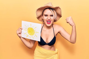 Bikini ve yaz şapkası takan genç, sarışın bir kadın sinirlenmiş ve sinirlenmiş bir şekilde bağırıyor. Öfkeyle bağırıyor ve el kaldırıyor. 