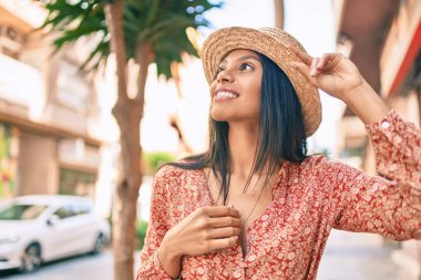 Genç Afro-Amerikan turist kadın tatilde gülümseyerek şehirde mutlu bir şekilde yürüyor..