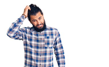 Gündelik giysiler giyen genç bir Arap 'ın kafası karışıyor ve soru soruluyor. Şüpheyle kararsız, kafa kafaya düşünerek. Düşünceli kavram. 